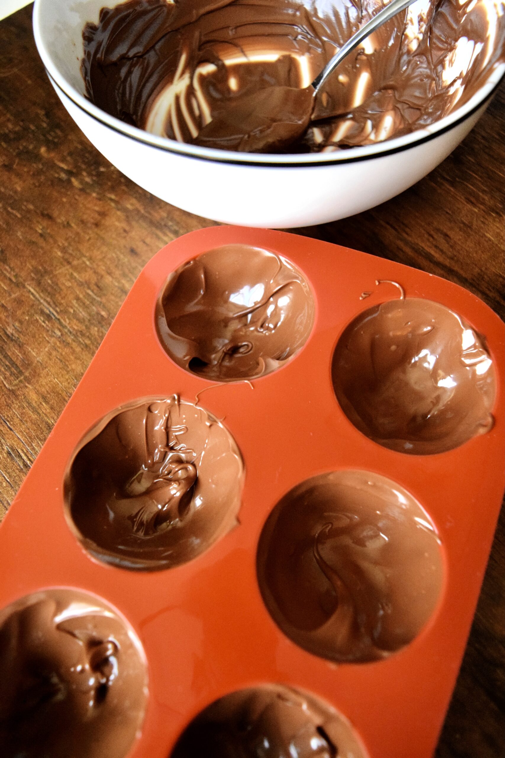 use a spoon to coat the moulds in chocolate