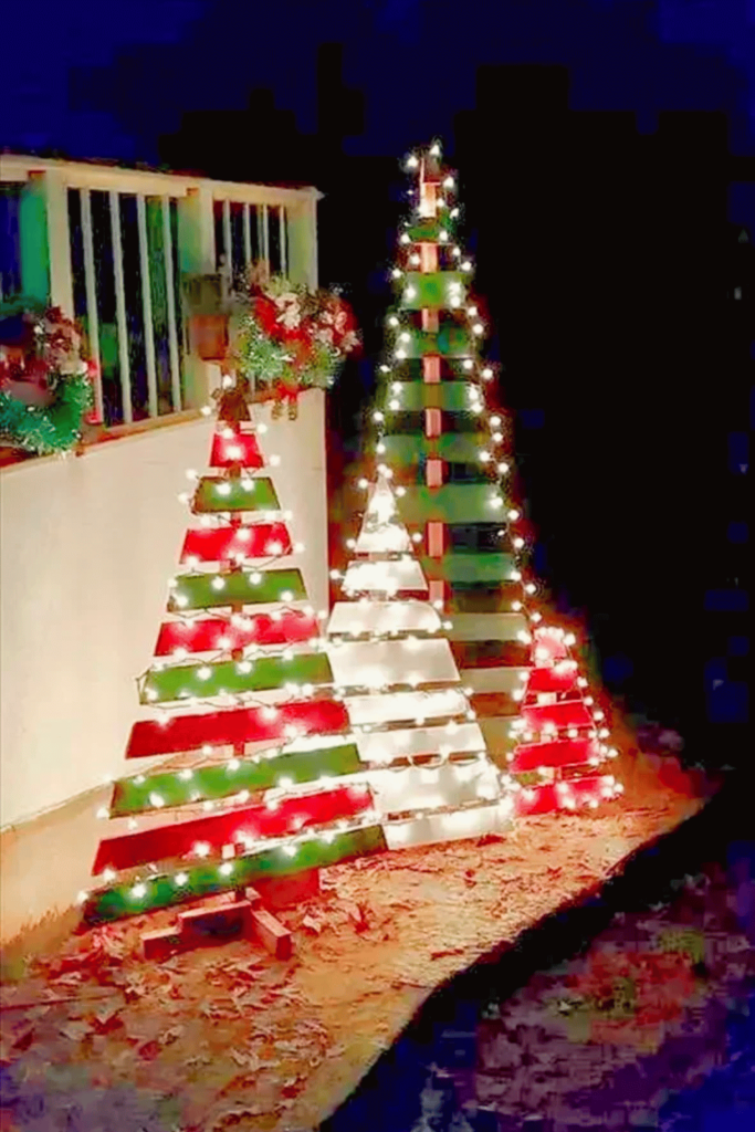 DIY Pallet wood trees painted red, green and white and decorated with fairy lights