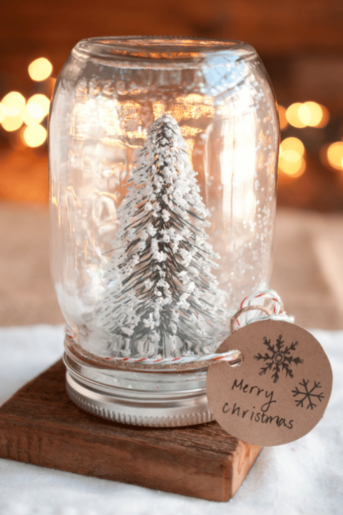 A handmade snow globe that contains a snowy tree inside an upside down mason jar