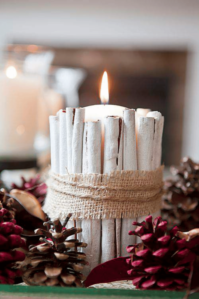 Candle surrounded with cinnamon sticks held with burlap ribbon