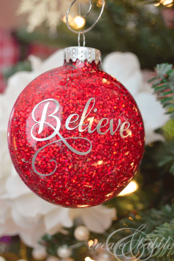 Red glitter ornament with Believe monogram on the front