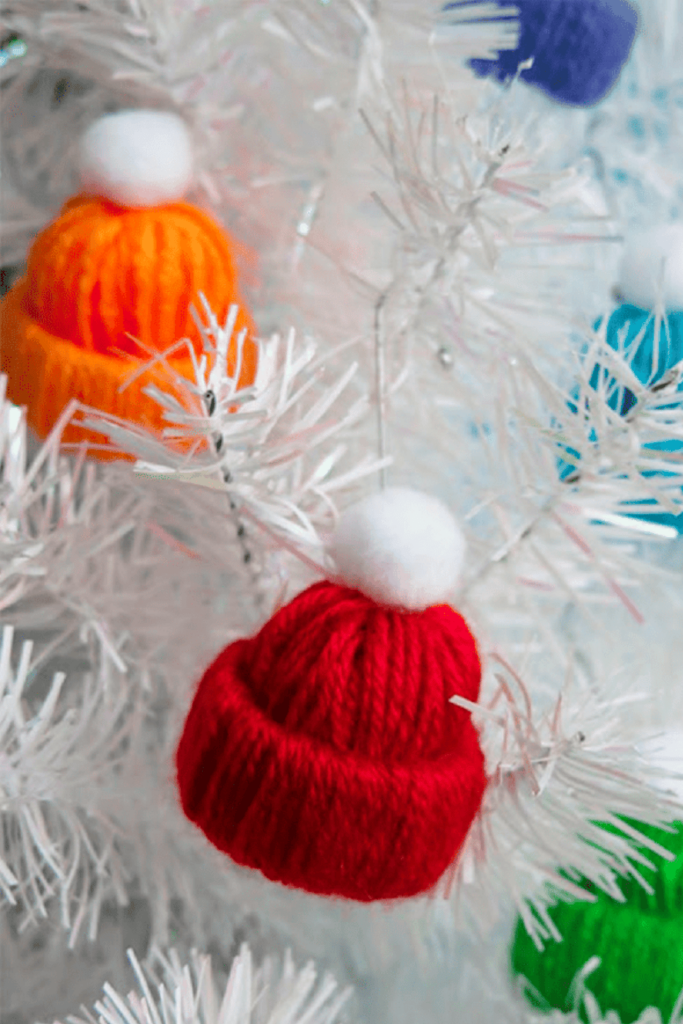 Mini bobble hat garland hanging on a white tree