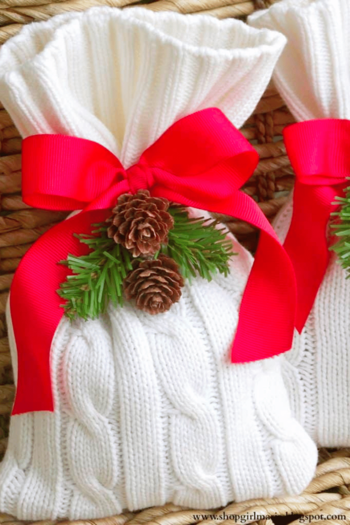 Knitted bags tied with red ribbon and pine cones