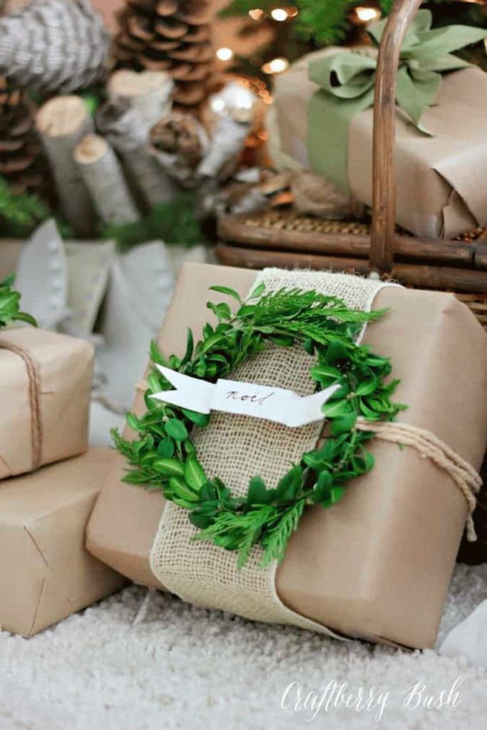 A small gift topped with a handmade boxwood wreath