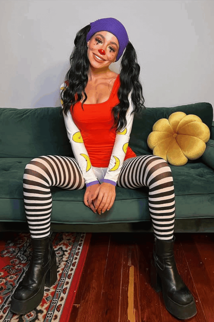Woman dressed as Loonette from The Big Comfy Couch with striped tights, banana-print sleeves, and playful clown makeup.