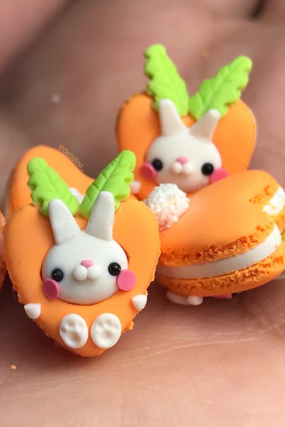 Orange carrot-shaped macarons with adorable bunny faces and leafy green accents.