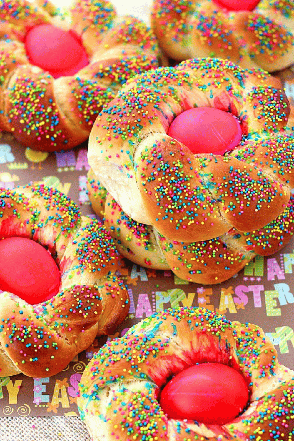Sweet braided bread decorated with colorful sprinkles and dyed Easter eggs.