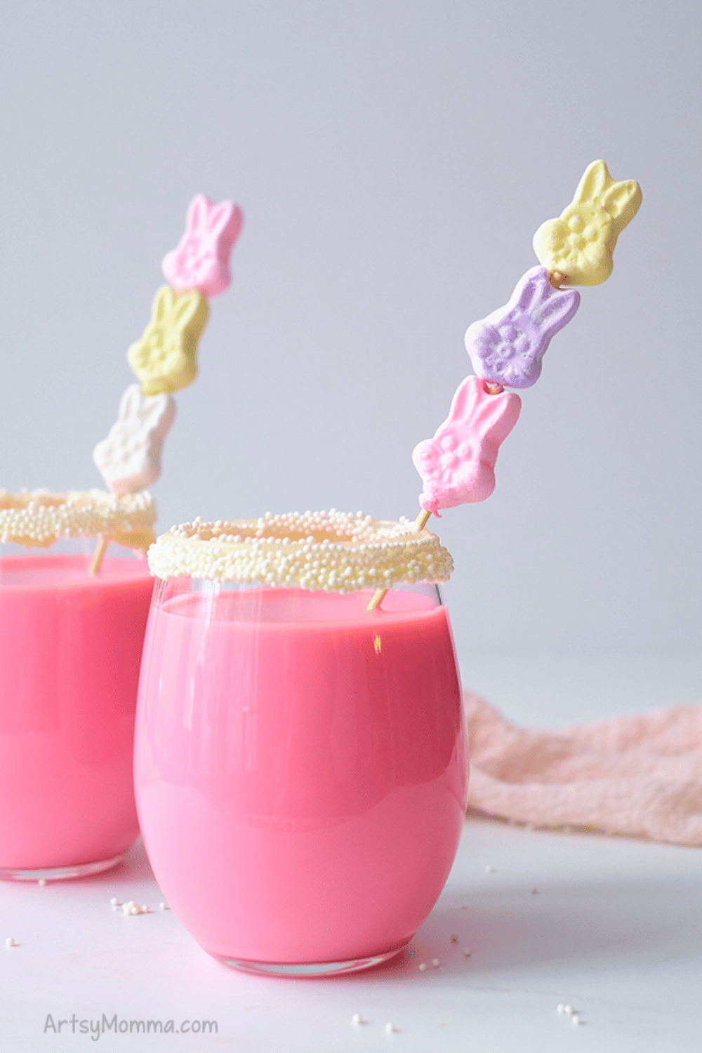 Pink marshmallow drinks in glasses decorated with sprinkles and skewered bunny-shaped marshmallows.