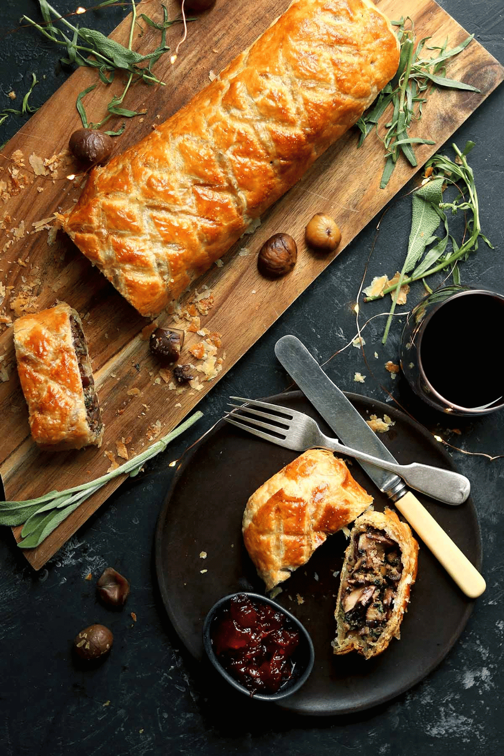 Mushroom Wellington wrapped in golden puff pastry, sliced to reveal the filling.