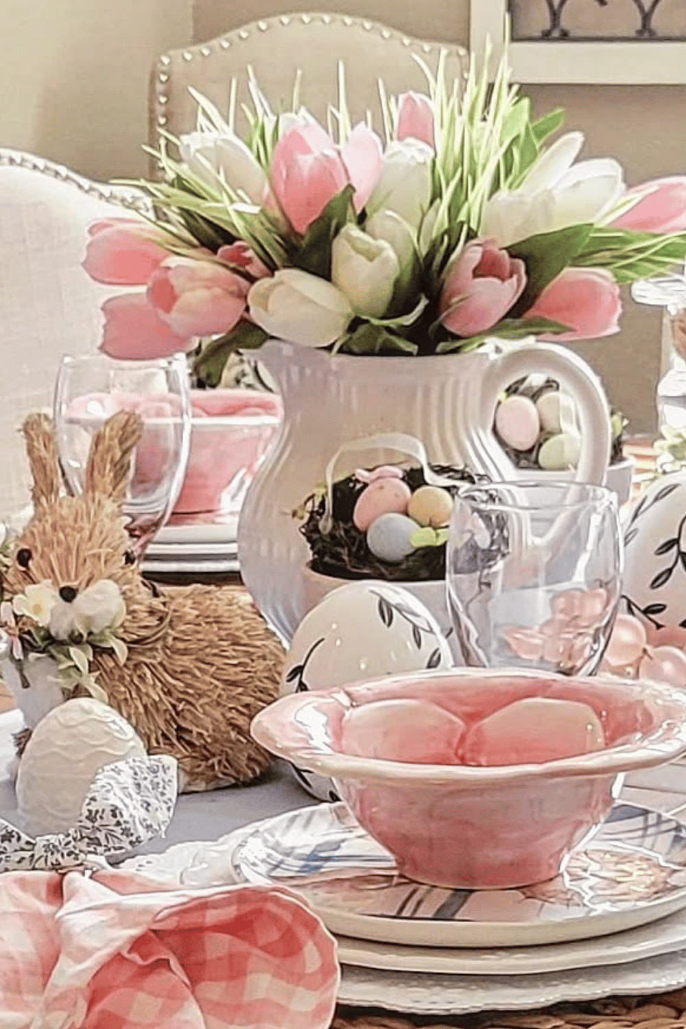 Pretty pink gingham Easter Tablescape with tulips, straw bunnies, and a soft pastel Easter dinner table setting.