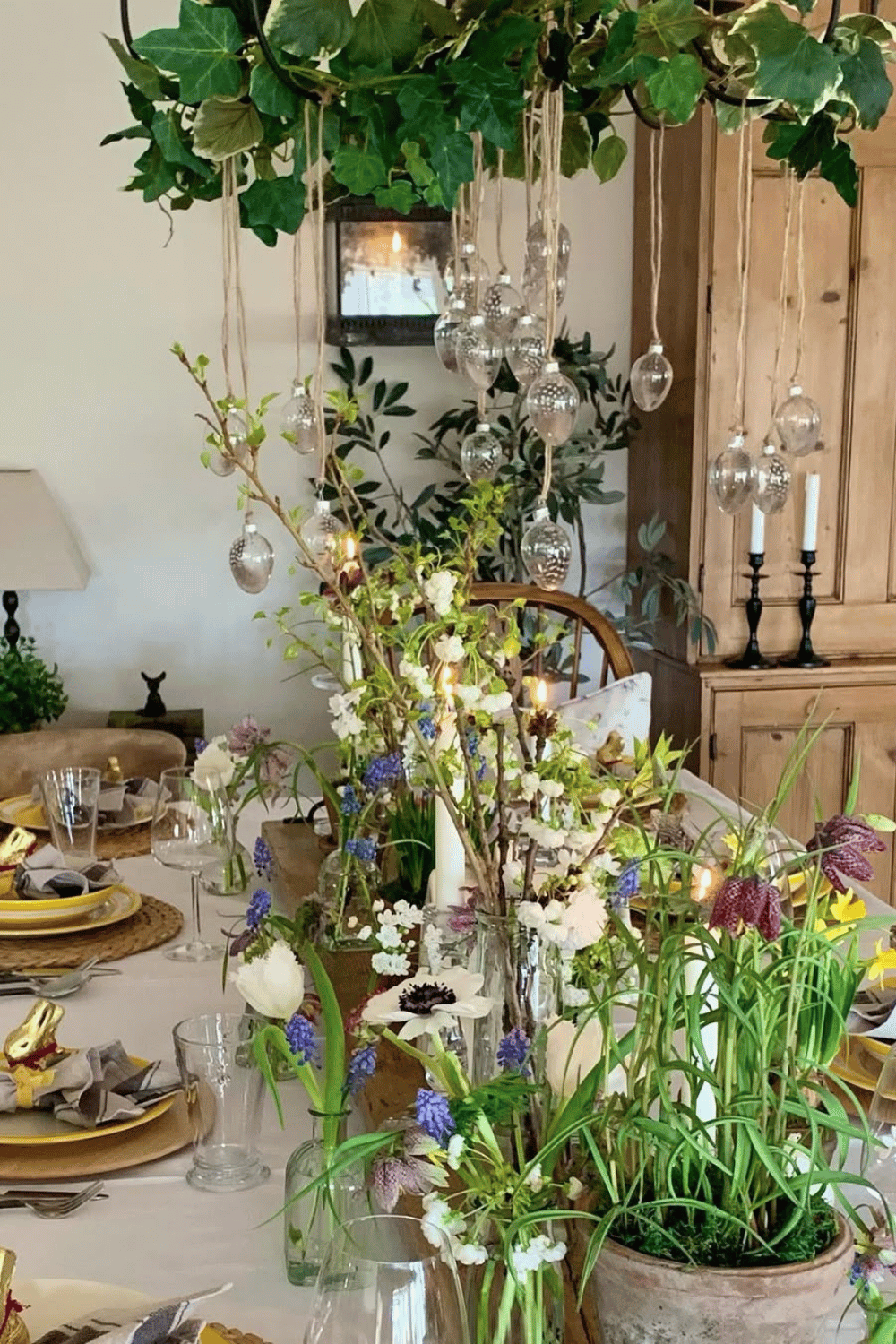 Spring garden-inspired Easter Tablescape with hanging glass orbs, fresh wildflowers, and rustic table elements.