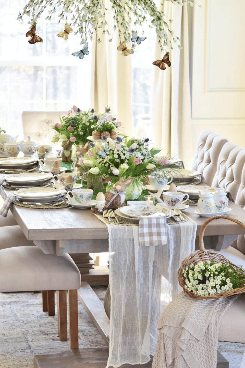 Butterfly meadow Easter dinner table setting with delicate china, soft linens, and floating floral decor.