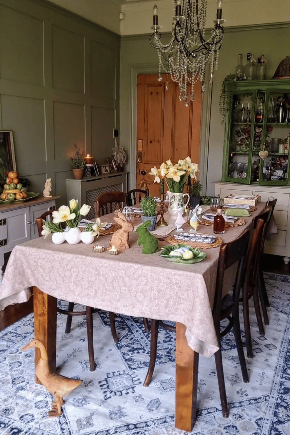 Rustic cozy Easter hosting ideas with warm candlelight, woven chargers, and daffodil centerpieces.