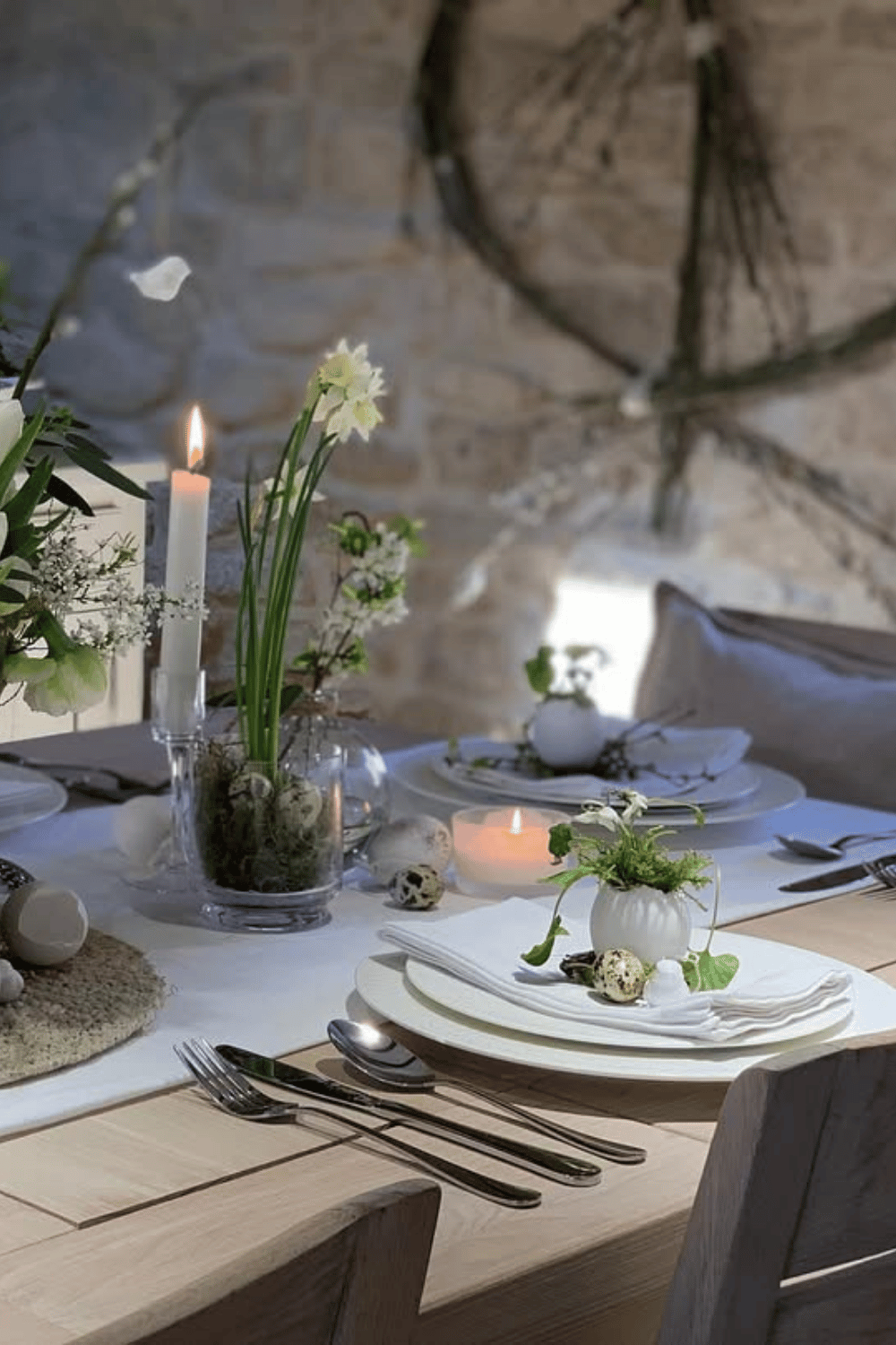 Minimalist candlelit Easter dinner table setting with soft white decor, linen napkins, and seasonal florals.