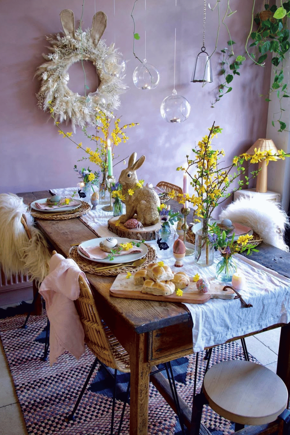 Rustic boho Easter table ideas featuring an oversized bunny wreath, warm wood tones, and wildflower accents.