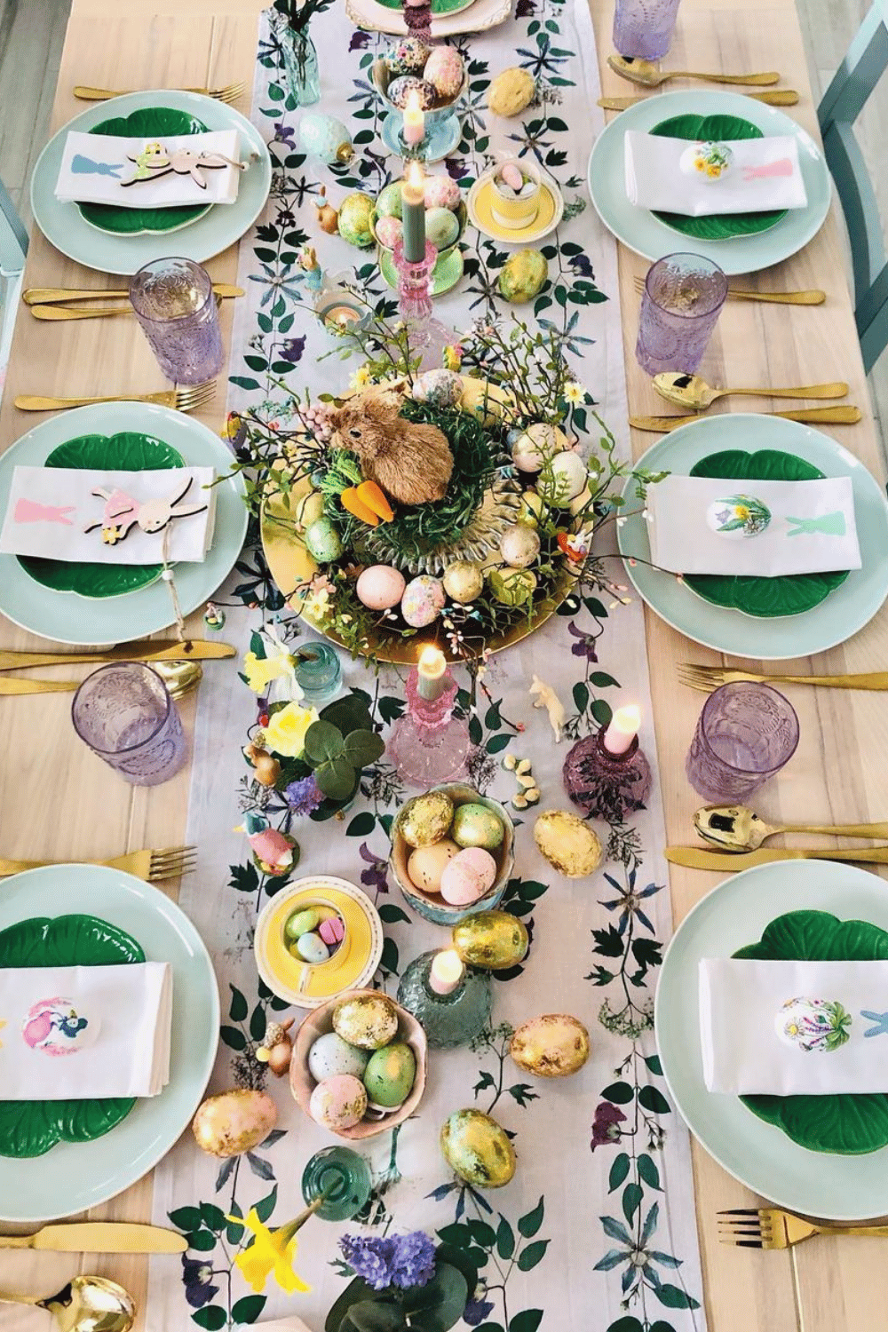 Colorful Easter table with a floral table runner, Easter eggs, and bunny-themed tablescape accents.