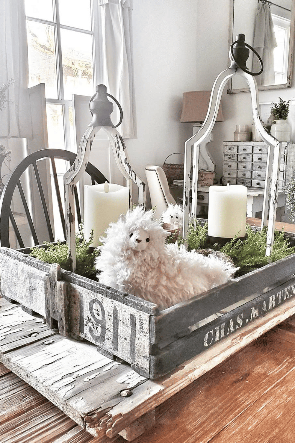 Tiered tray decor with a plush lamb, candles, and greenery.