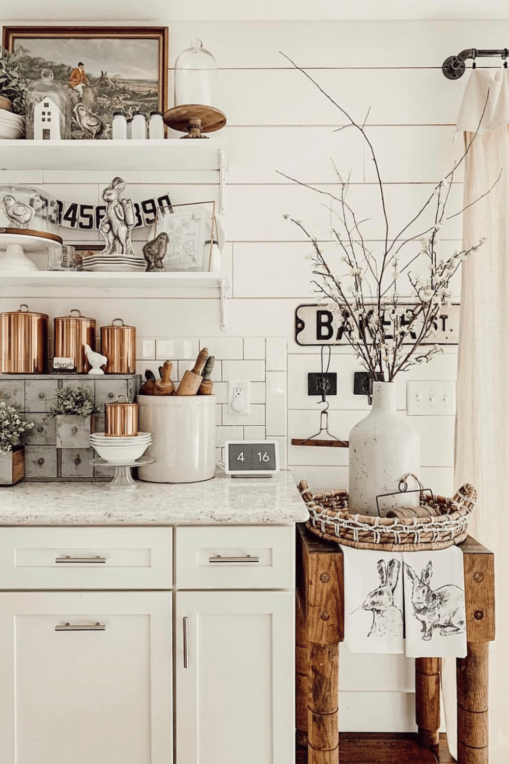 Farmhouse kitchen decorated with Easter towels, vintage prints, and wooden accents.