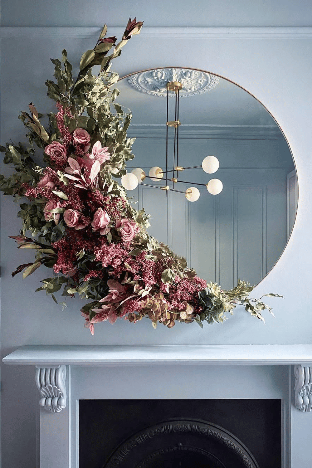 A mirror displays an elegant asymmetrical floral Easter wreath.