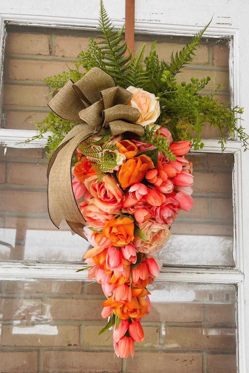 This Easter wreath combines the shape of a carrot with tulips and burlap ribbon.