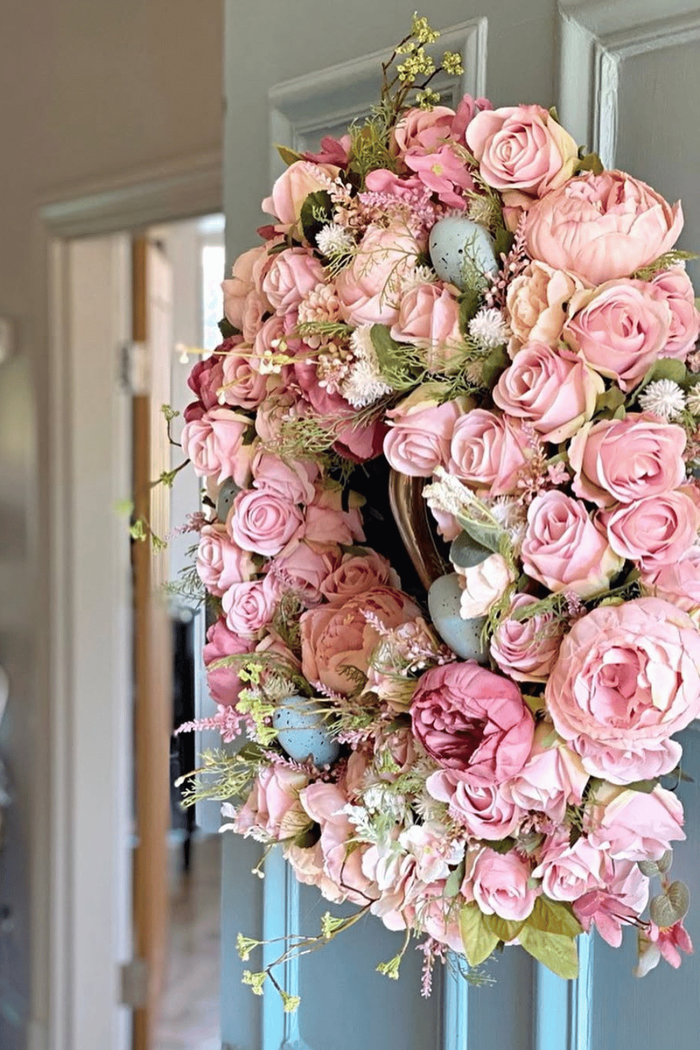 The Easter wreath features romantic pink roses combined with Easter eggs enhanced by soft pastel tones.