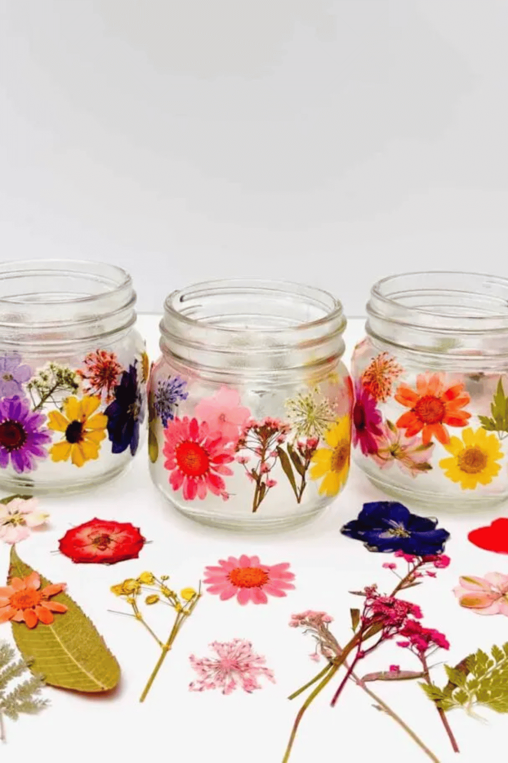 DIY mason jar candle holders decorated with pressed flowers for spring centerpiece