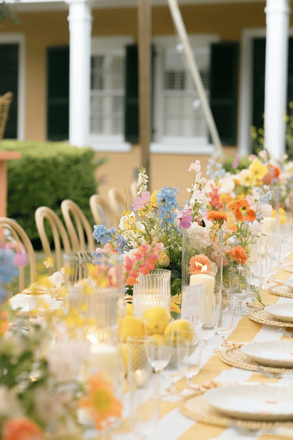 Outdoor spring tablescape with wildflowers, lemons, and candles for a fresh spring gathering