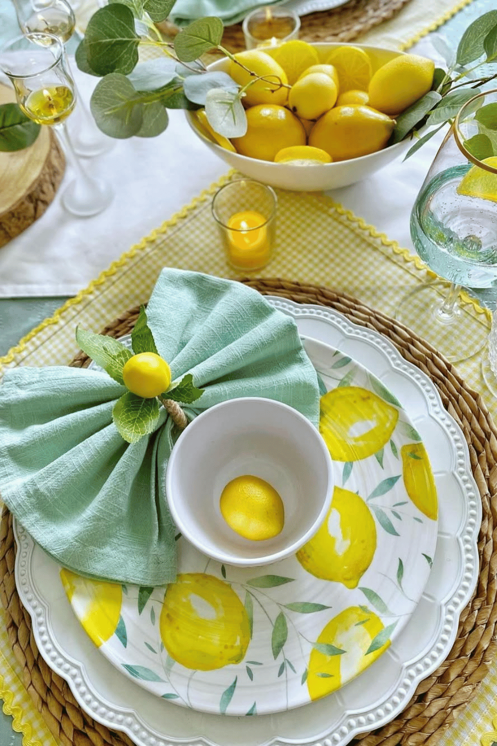 Citrus-inspired spring table setting with lemons, yellow-patterned plates, and greenery napkin decor