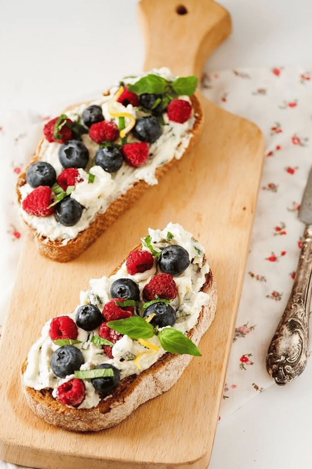 Basil and cream cheese toast topped with cherry tomatoes and blueberries
