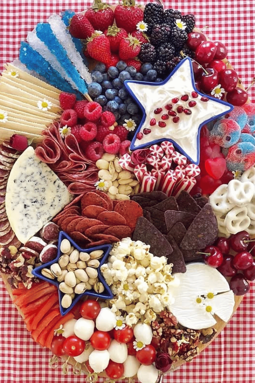 Festive snack board with patriotic candies, fruits, nuts, and cheese