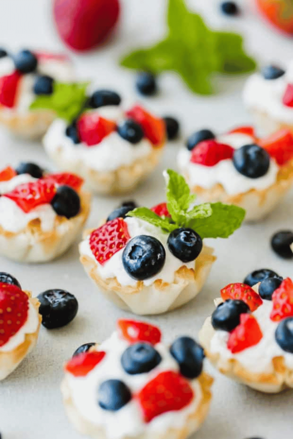 Mini Greek yogurt fruit bites topped with strawberries, blueberries, and mint