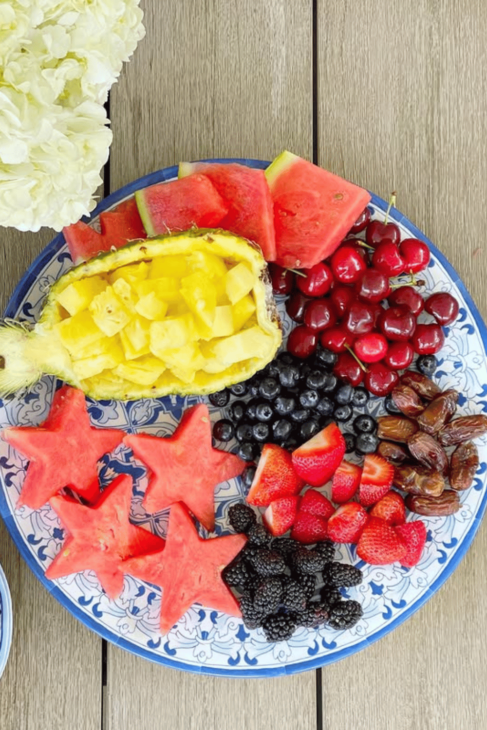 Fresh fruit platter with watermelon stars, pineapple, berries, and cherries