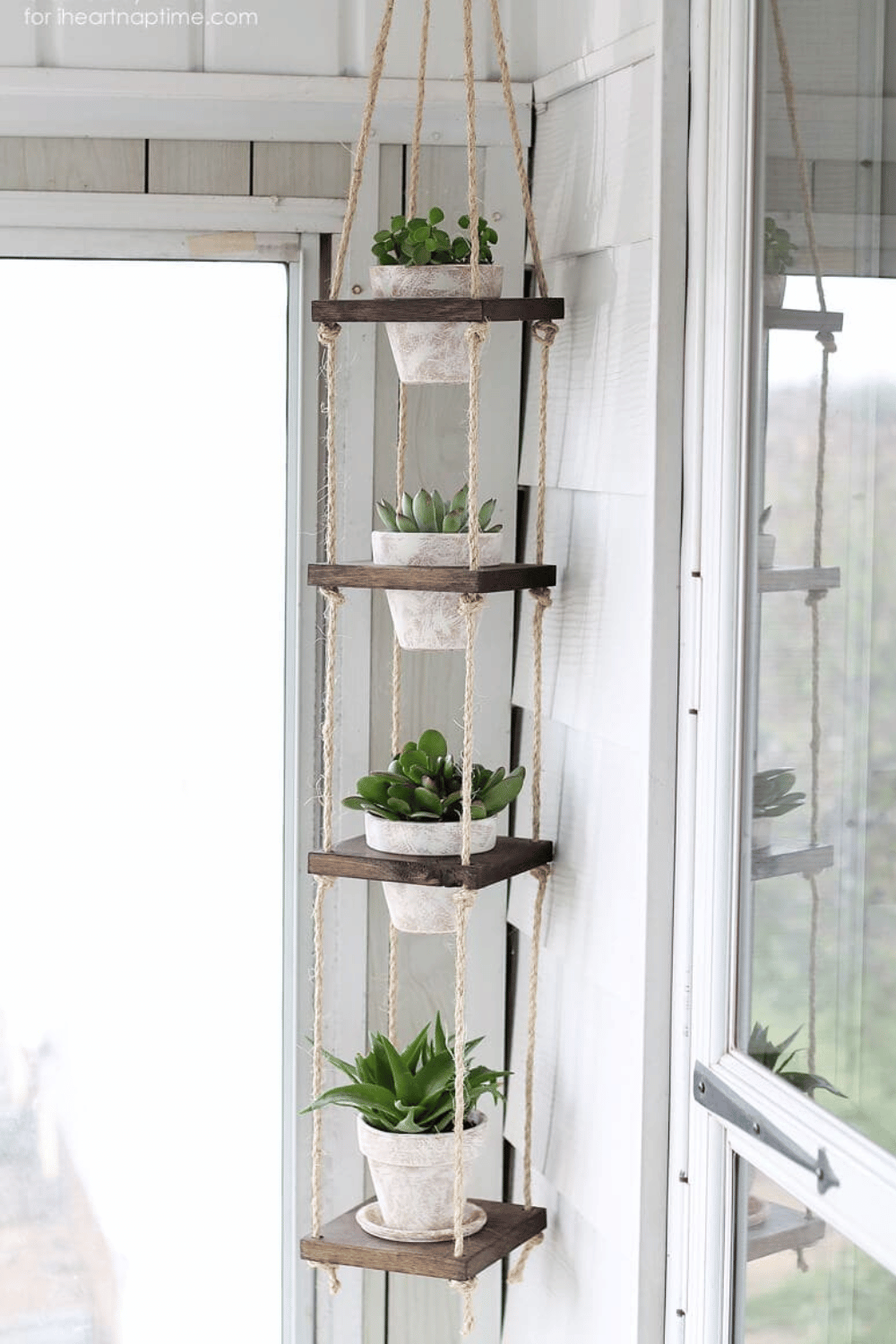 Vertical hanging plant shelf with greenery in white pots