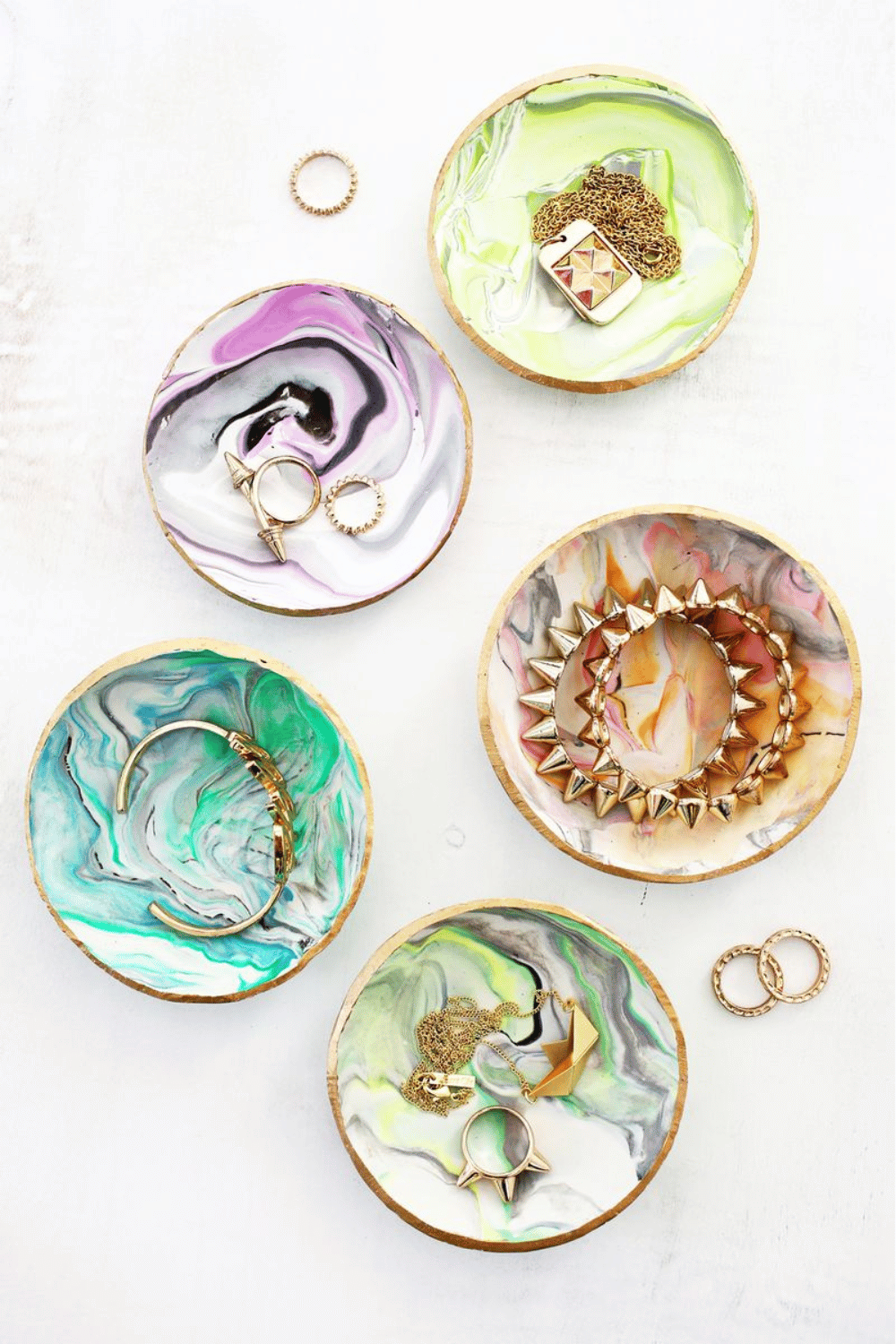 Elegant marbled clay ring dish with gold trim holding rings