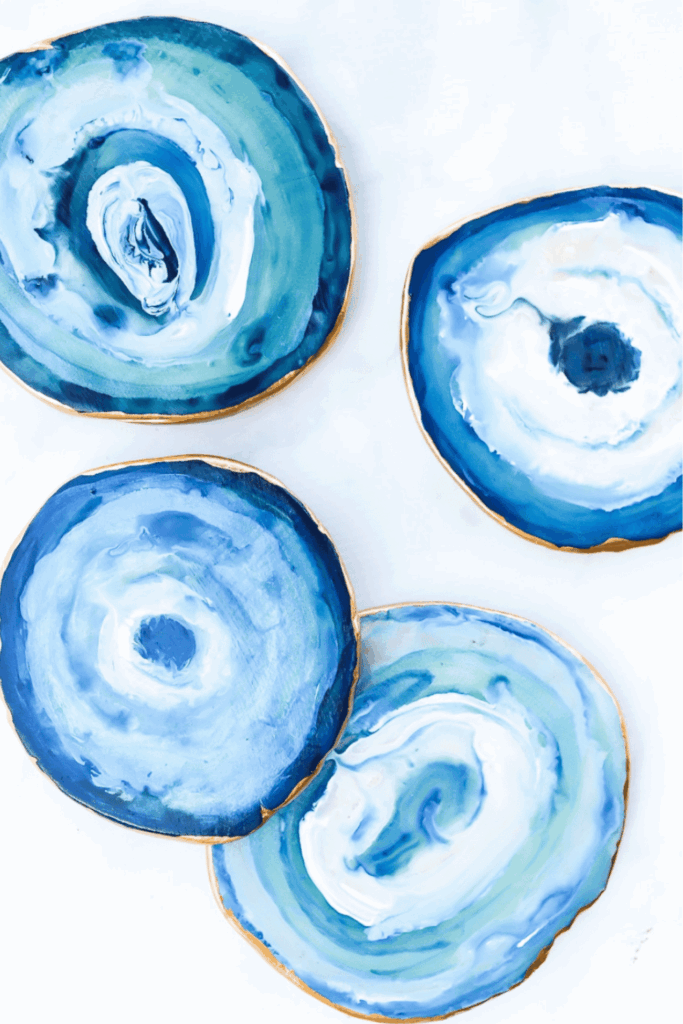 Hand-painted coasters with swirling blue resin designs