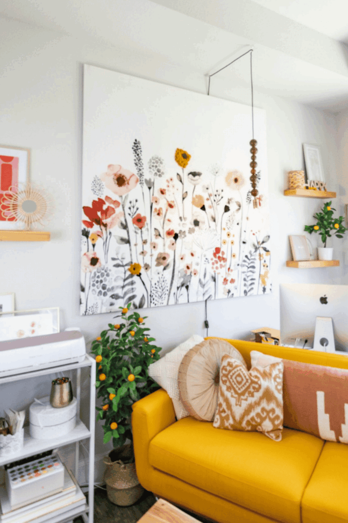 Bright, floral wall art hanging above a yellow couch in a stylish living room
