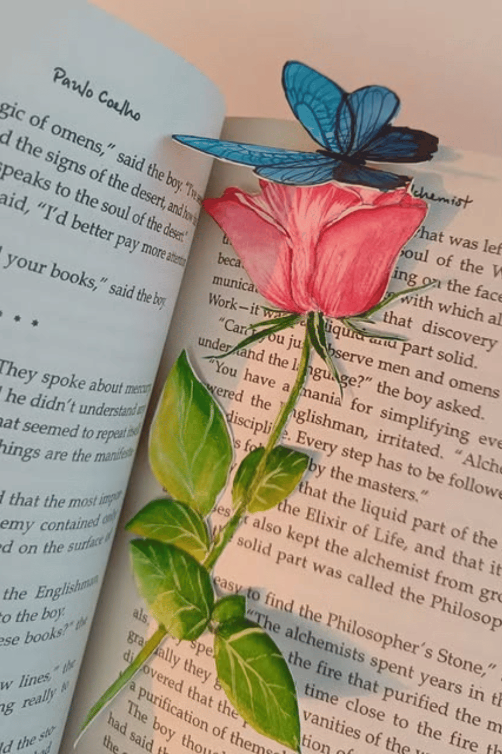Floral and butterfly paper bookmark peeking from an open book