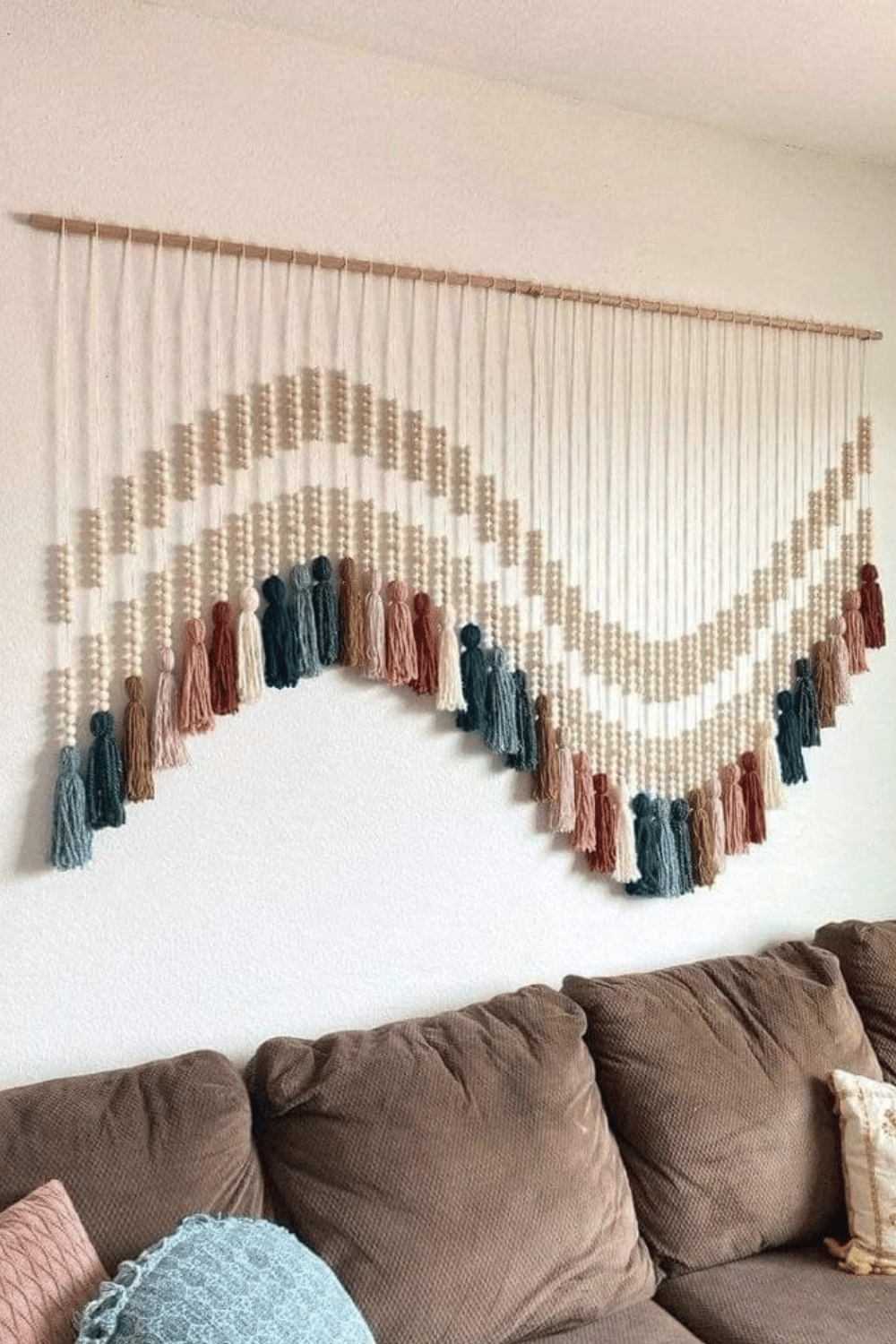 Macrame tassel wall hanging in natural and earthy tones above a couch