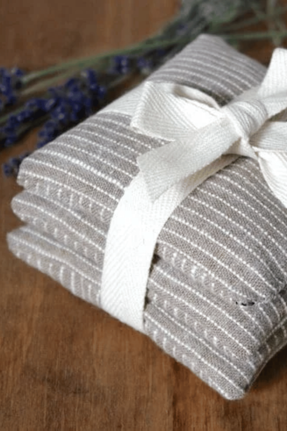 DIY lavender heat pack wrapped in striped cotton fabric with white bow.