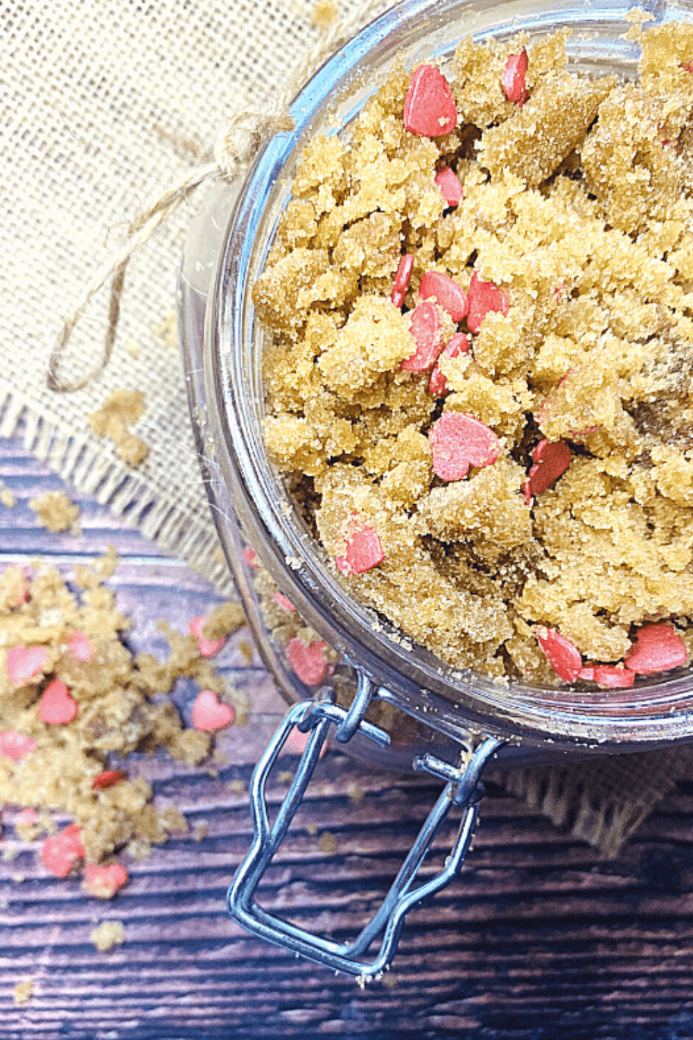 Brown sugar scrub with pink heart sprinkles in a glass jar