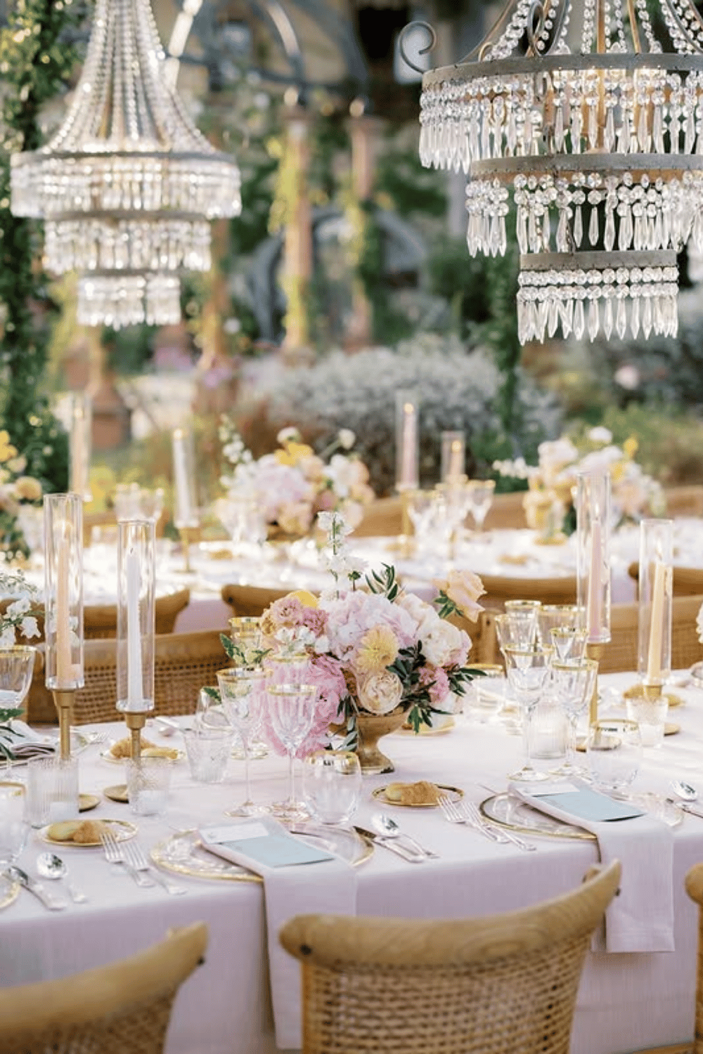 Chandelier-lit garden reception table with blush florals and crystal decor/ Reception Table Settings