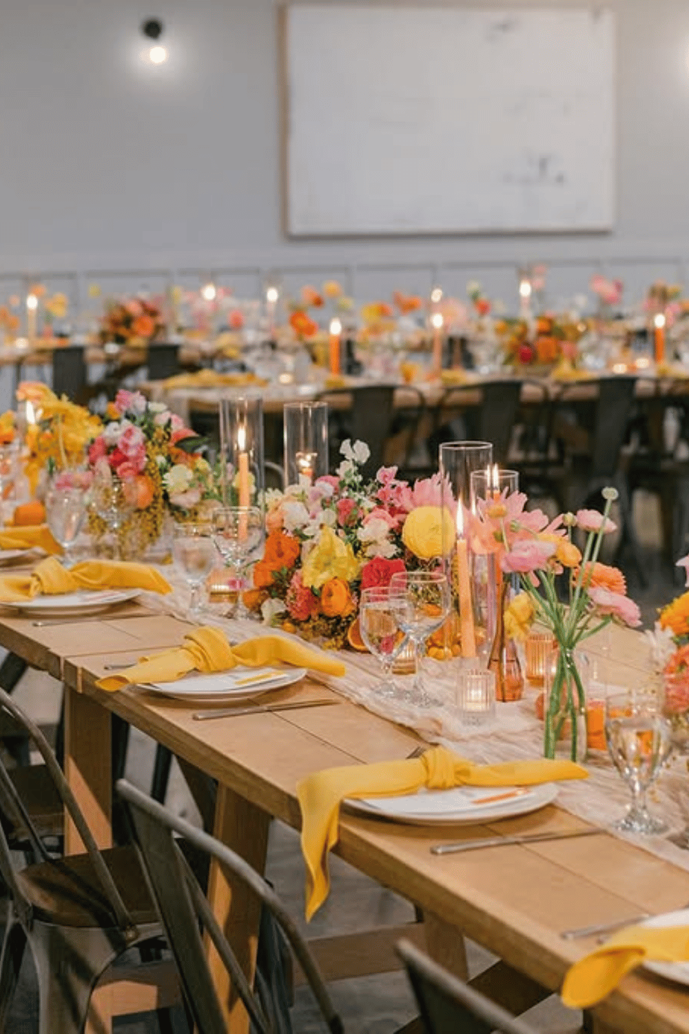 Bright and cheerful wedding table with yellow napkins and vibrant florals