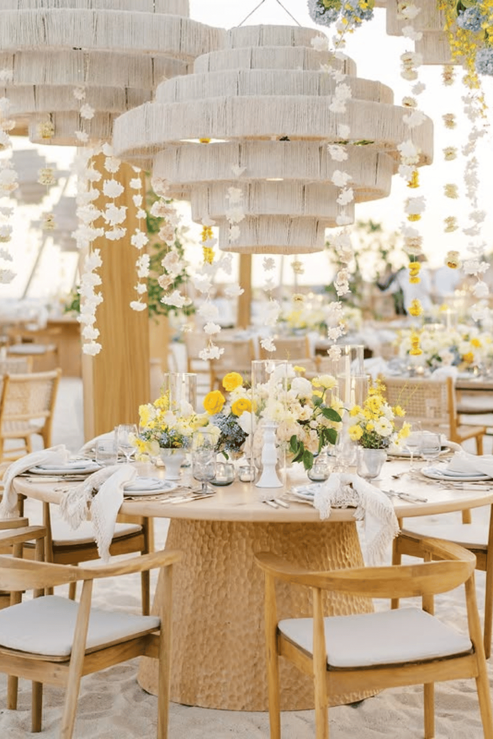 Boho beach wedding table with yellow and white florals and woven accents