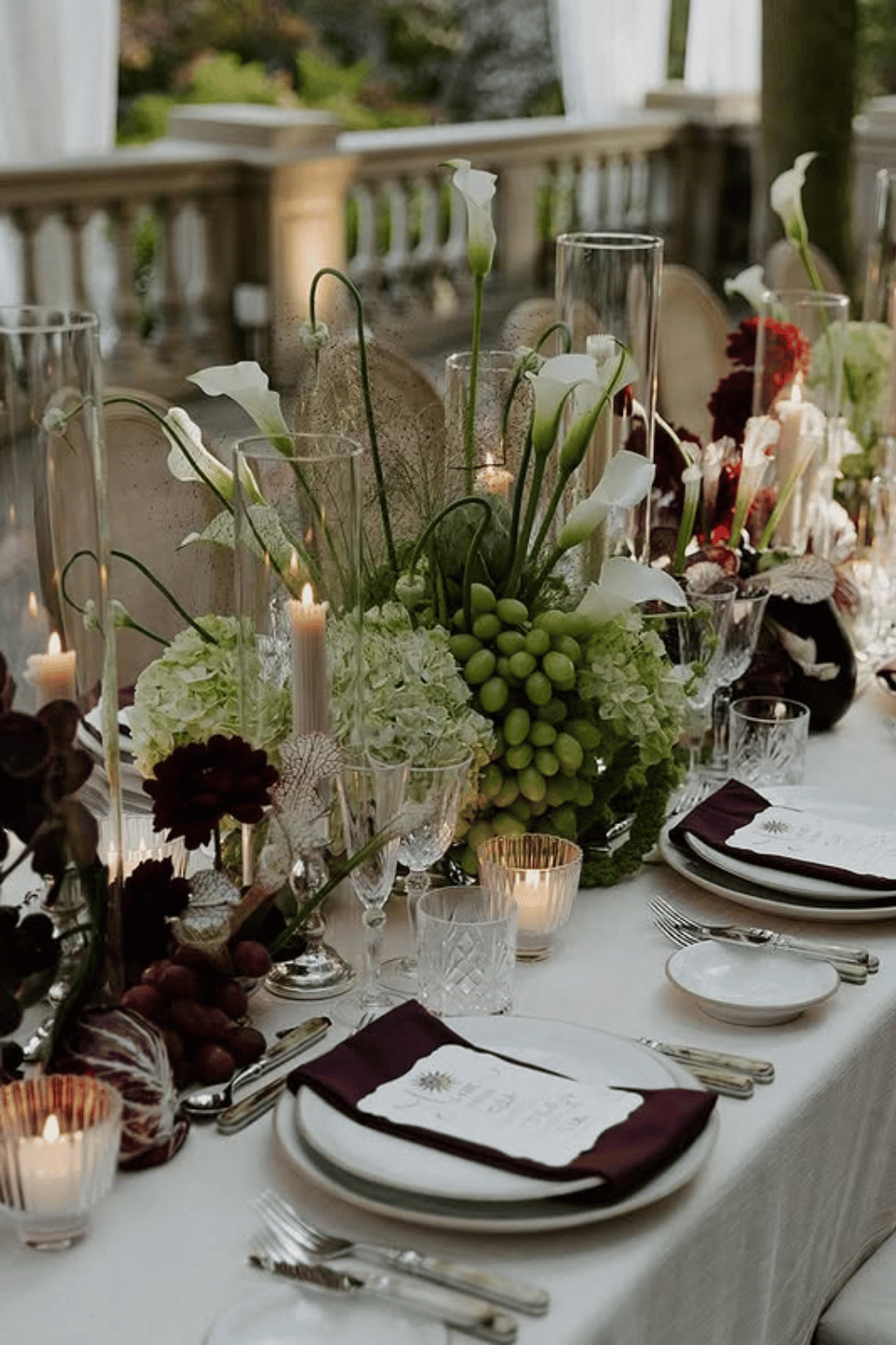 Garden wedding table with grapes, hydrangeas, and deep red floral centerpiece