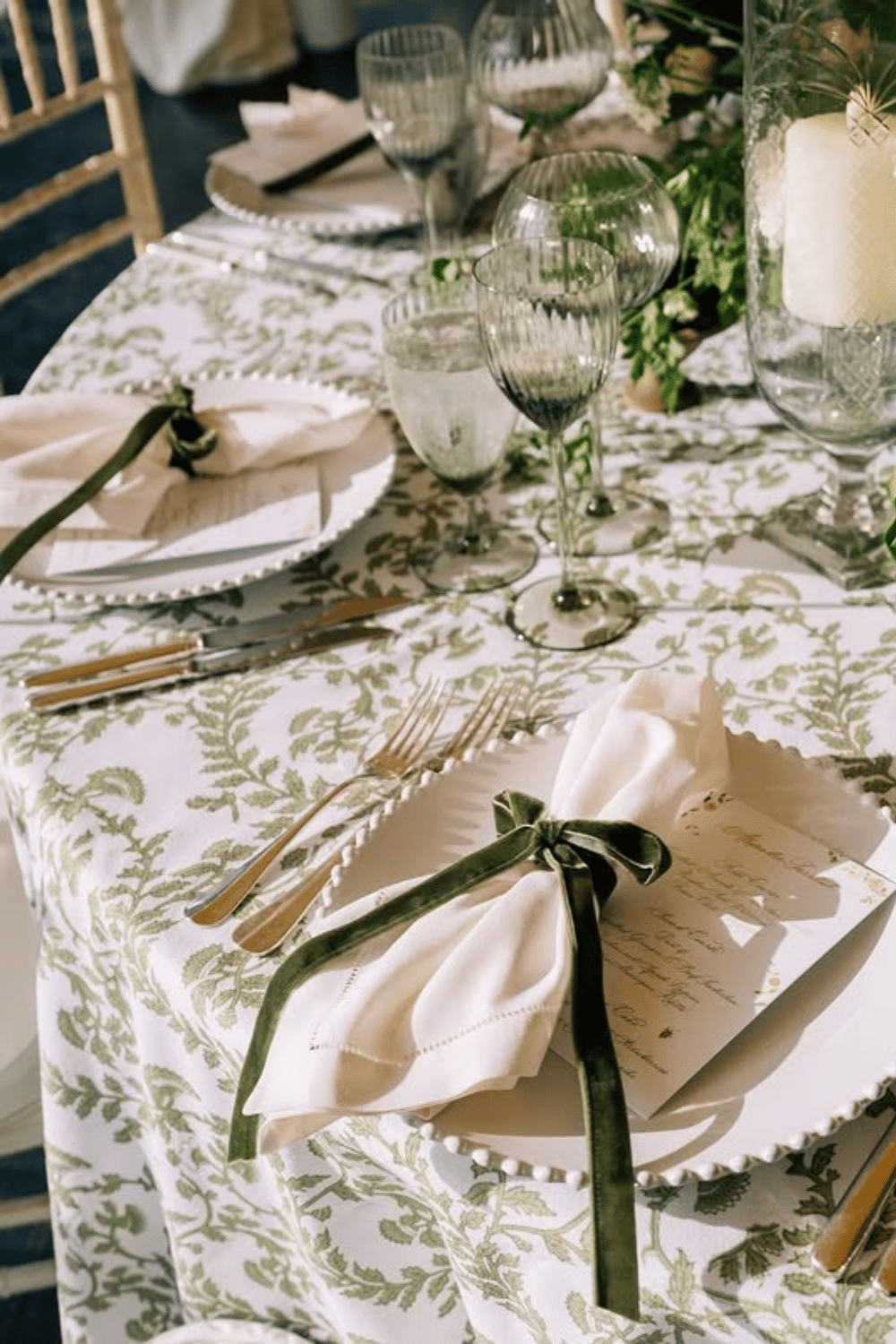 Botanical print tablecloth with green velvet-tied napkins and glass goblets