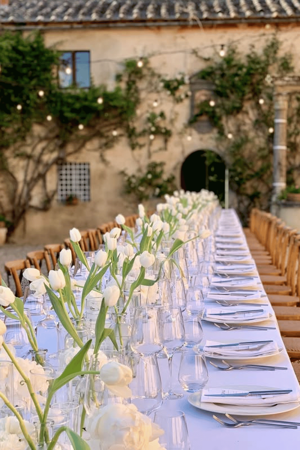 Minimalist all-white tulip tablescape with modern glassware and clean lines