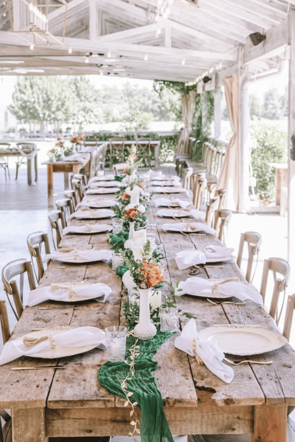 Rustic wood table with greenery, ivory linens, and candlelight. Simple Wedding Table Decor