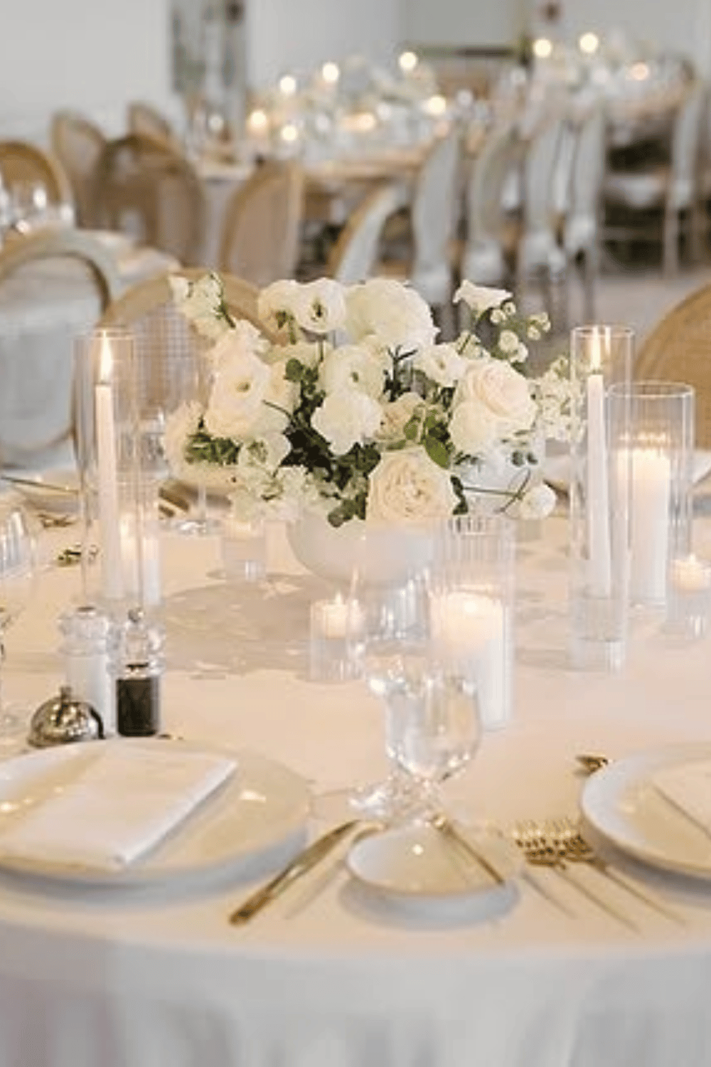 Classic white wedding table with rose centerpiece and soft candlelight