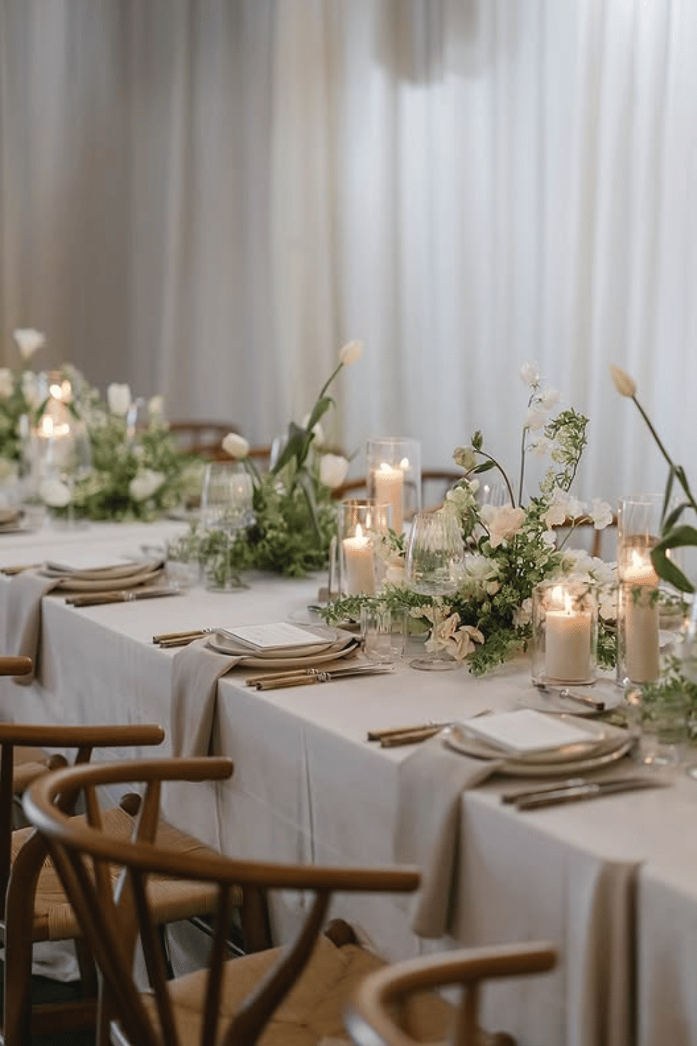 Soft green and white wedding table with tulips and candlelit ambiance