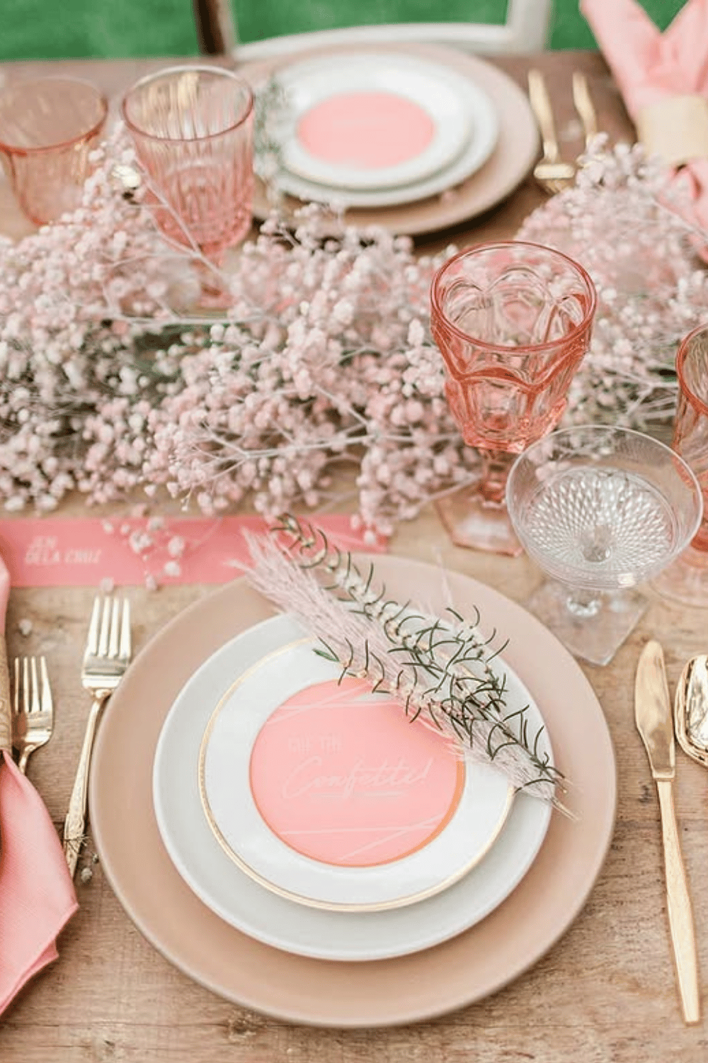 Monochrome pink wedding table with layered plates and blush glassware